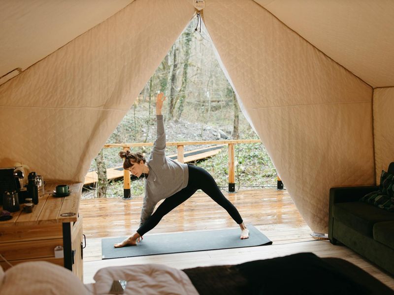 Person performing yoga sequence in a minimalist dark room